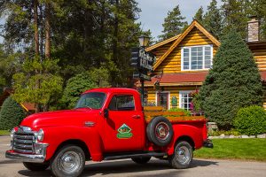 Exterior of cabin at Alpine Village Jasper with a red truck