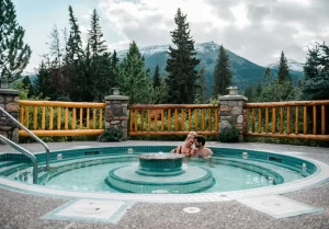 2 people enjoying the hot pool with stunning mountain views at Alpine Village