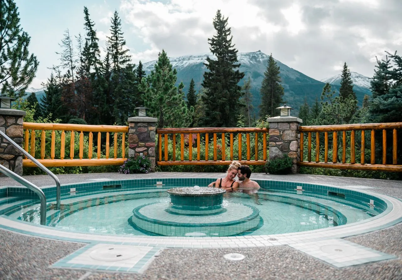 2 people enjoying the hot pool with stunning mountain views at Alpine Village