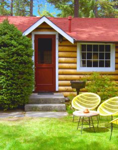 Exterior of small one room cabin with fireplace at Alpine Village Jasper