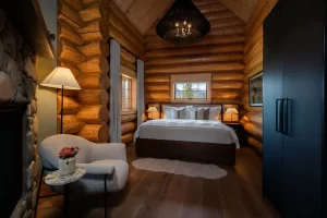 Bedroom, chair, and fireplace of the Executive One Bedroom Cabin