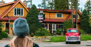 A woman outside in a hat looking at the Alpine Village main building