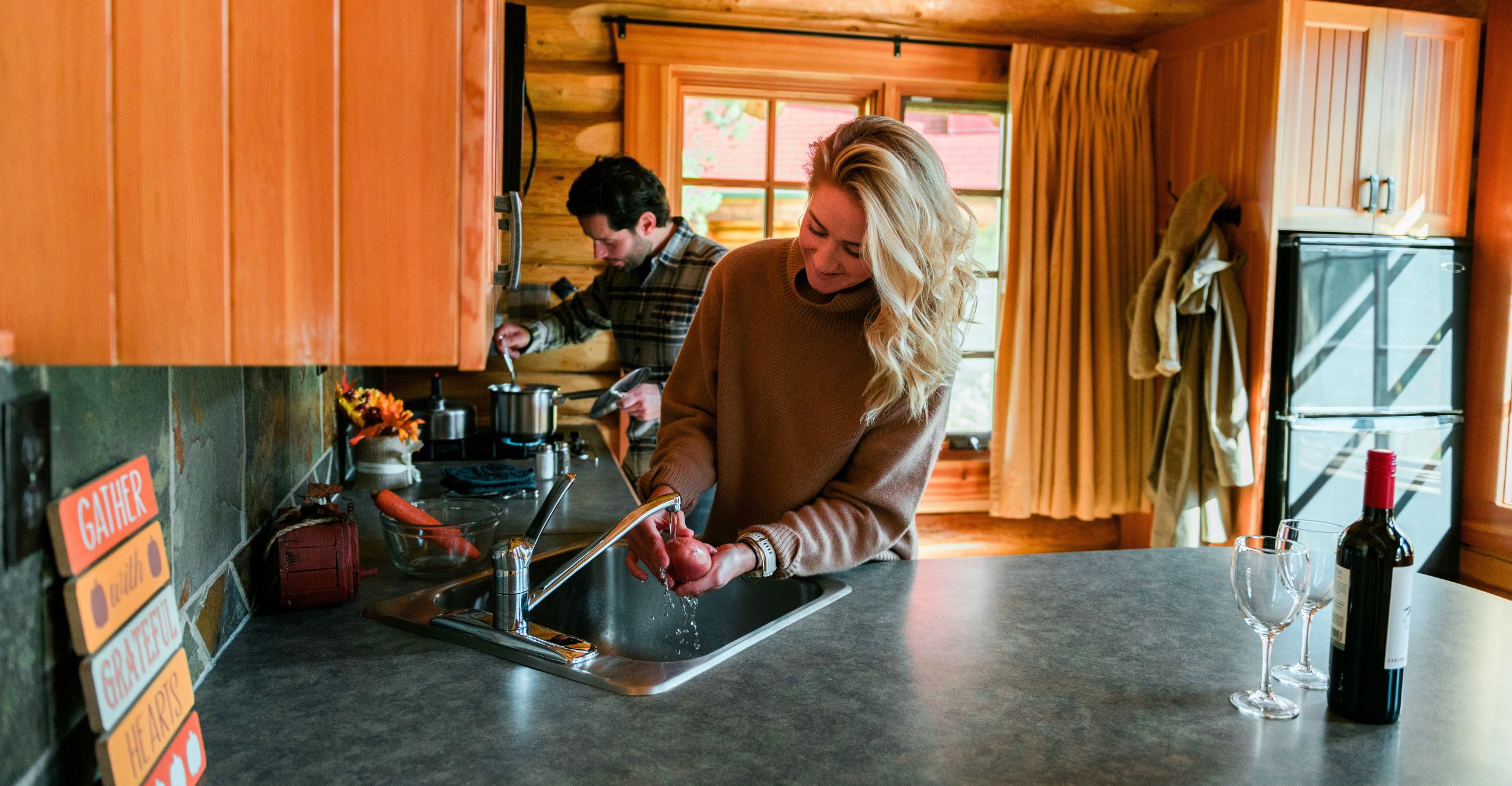 A couple cooking together in a cabin at Alpine Village Jasper