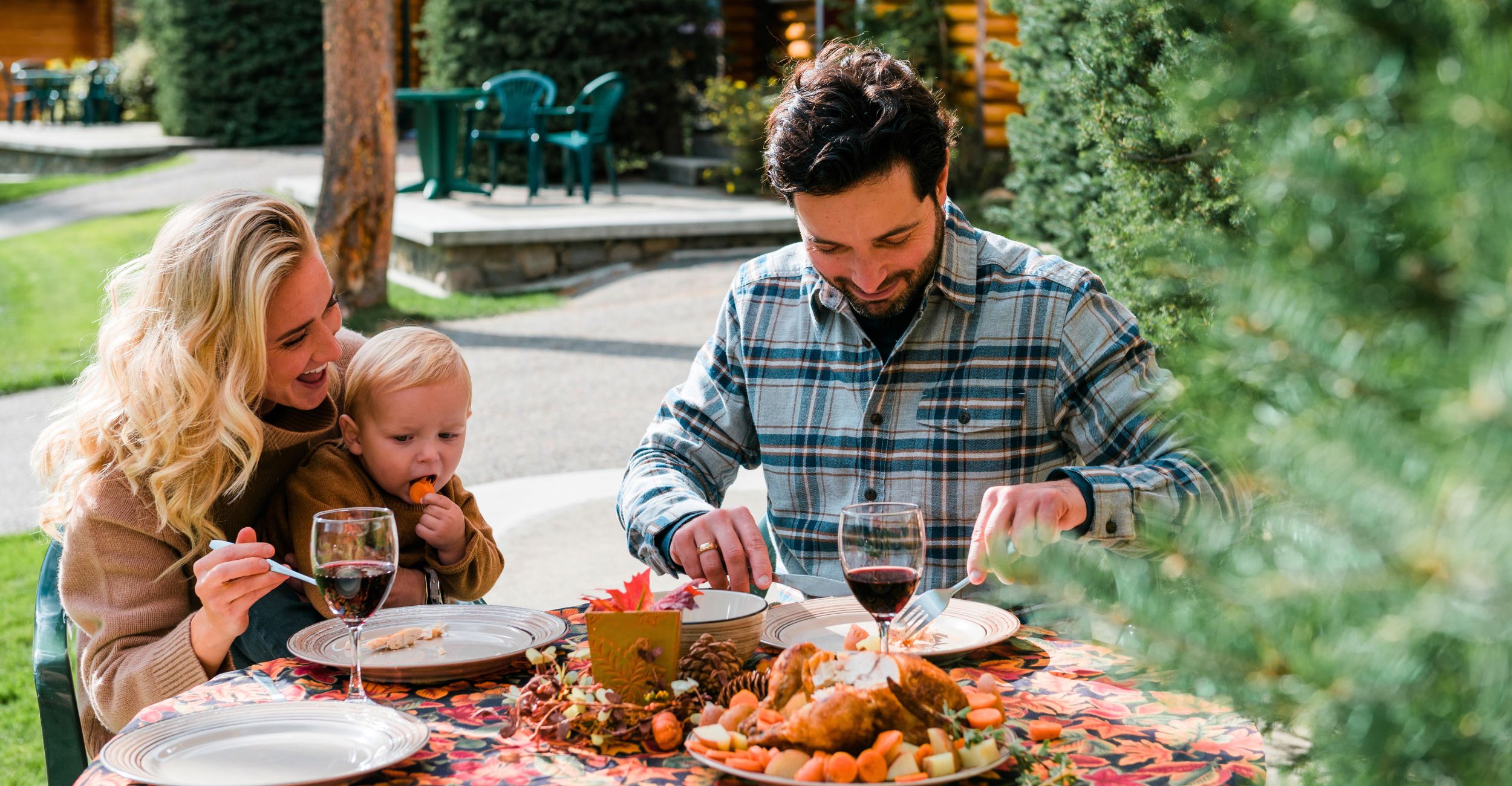 A young family eating together outside their cabin at Alpine Village