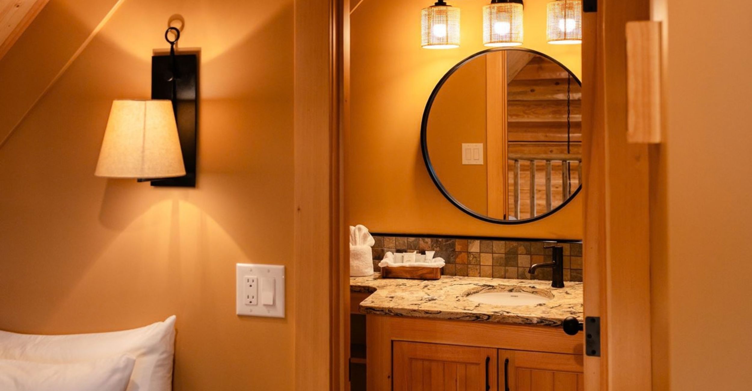 The upstairs of a newly built signature family cabin from next to the bed looking through into the toilet with a beautiful sink and mirror