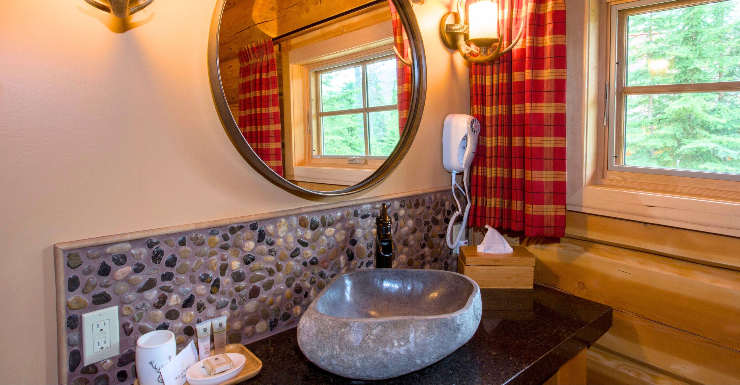 Whistler one bedroom cabin bathroom showing the bathroom with a stunning sink and a round mirror above the counter